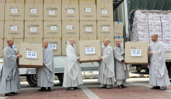 서울 견지동 조계사에서 13일 열린 북한 수해 지원 물품 상차식에서 총무원장 자승 스님(왼쪽에서 세 번째)을 비롯한 스님들이 구호품을 차에 싣고 있다.  정연호기자 tpgod@seoul.co.kr