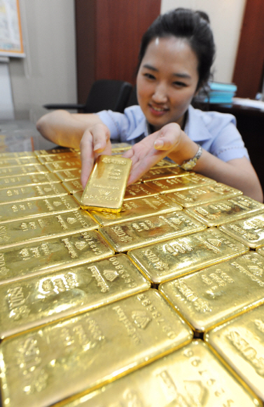 미 달러화 가치 하락과 안전자산 투자심리 등으로 국제 금값이 사상 최고치를 기록한 15일 서울 종로3가 신한은행에서 직원이 골드바를 정리하고 있다. 도준석기자 pado@seoul.co.kr