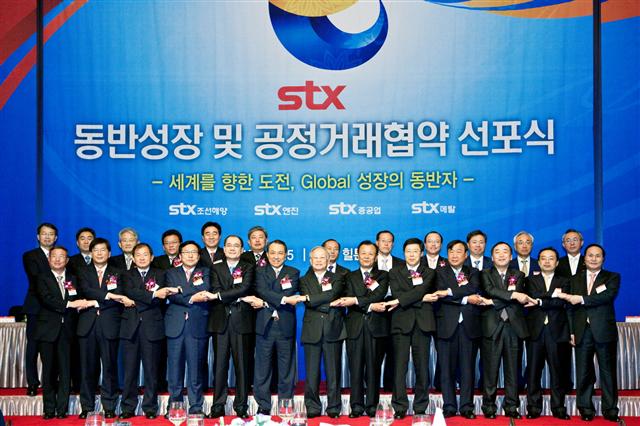 15일 서울 남대문로 밀레니엄힐튼호텔에서 열린 ‘STX동반성장 및 공정거래 협약 선포식’에서 참석자들이 손을 잡고 기념 사진을 찍고 있다. STX 제공