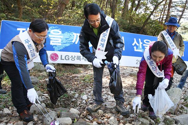 남상건(가운데) LG상록재단 부사장과 정윤석(왼쪽) 재단 상무가 15일 경기 포천시 명성산에서 재단 직원들과 함께 오물을 수거하고 있다. LG그룹 제공