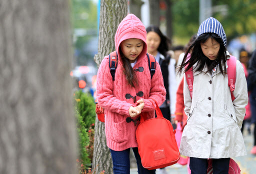 차가운 바람이 불면서 추운 날씨를 보인 25일 오전 서울시내 거리에서 초등학생들이 등굣길을 서두르고 있다. 연합뉴스