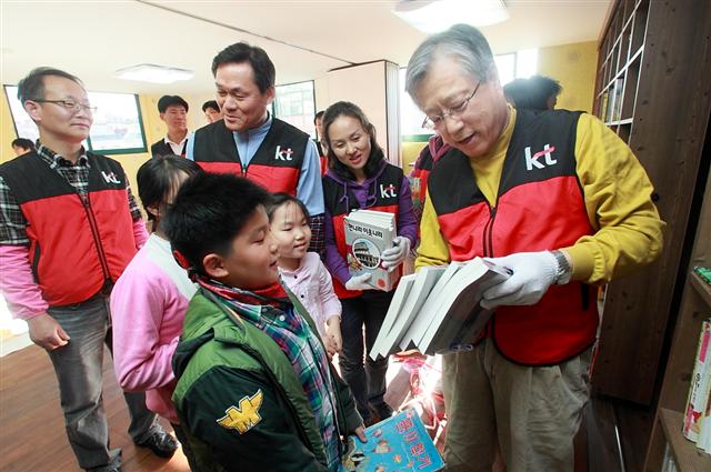 2일 경기 성남 ‘즐거운학교 지역아동센터’에서 이석채(오른쪽) KT 회장이 어린이들과 함께 책을 정리하며 ‘미니 도서관’을 꾸미고 있다. KT 제공