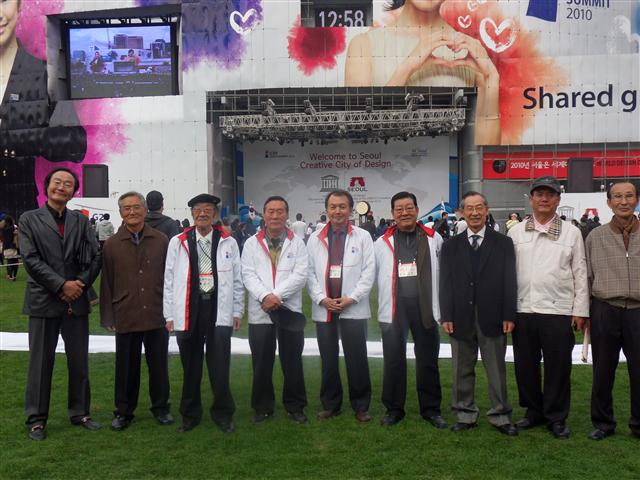 지난달 31일 서울광장에서 열린 G20 자원봉사 활동 발대식에서 안성균(왼쪽 세 번째), 이민희(오른쪽 세 번째)씨 등 서울시 시니어전문자원봉사단이 성공을 기원하며 포즈를 취하고 있다. 서울시 시니어전문자원봉사단 제공 