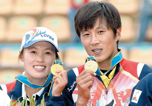 15일 정구 혼합복식에서 금메달을 딴 지용민(오른쪽)과 김경련이 시상대에서 메달을 손에 들고 포즈를 취하고 있다. 광저우 연합뉴스