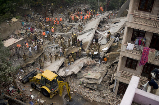 인도 수도 뉴델리에서 건물 붕괴 사고가 일어난 다음 날인 16일 구조대원들이 형체도 없이 무너진 건물 잔해들을 뒤져 매몰자를 찾고 있다. 이 사고로 70여명이 숨지고 130여명이 다쳤다. 뉴델리 AFP 연합뉴스