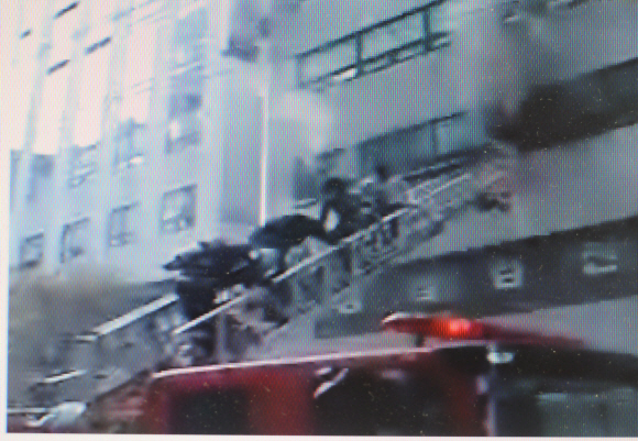 출동한 소방대원들이 구조용 사다리차를 이용해 건물 안으로 진입하고 있다.  MBC TV 화면 촬영
