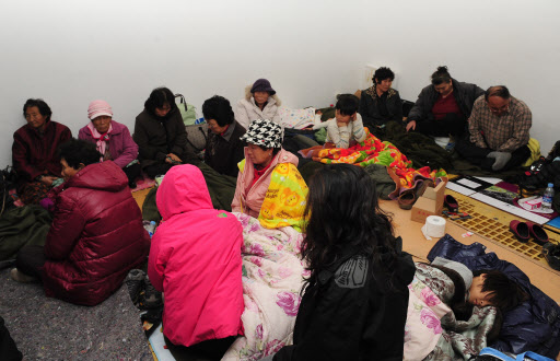 북한의 연평도 포격으로 인근 방공호로 긴급 대피한 주민들이 24일 새벽, 추위속에 한데 모여 앉아 있다.  연합뉴스