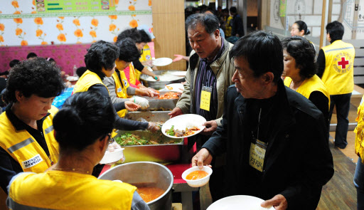 28일 오전 임시숙소인 인천시 중구 신흥동 대형 찜질방 인스파월드에서 연평도 피난민들이 식사 배식을 받기위해 길게 줄서고 있다. 연합뉴스