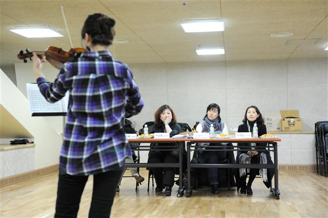 일반인에게 오케스트라 참여 기회를 제공하는 세종나눔앙상블의 오디션에서 심사위원들이 김영경(뒤)의 연주를 경청하고 있다.  세종문화회관 제공