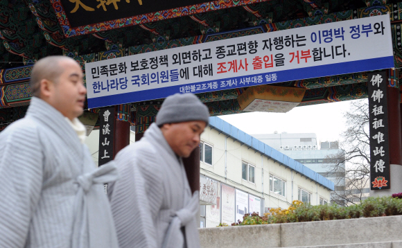 템플스테이 예산 삭감으로 불교계의 반발이 확산되고 있는 가운데 스님들이 10일 서울 종로 조계사 정문에 내걸린 이명박 정부와 한나라당 국회의원들의 출입을 거부하는 현수막 밑을 지나가고 있다. 정연호기자 tpgod@seoul.co.kr