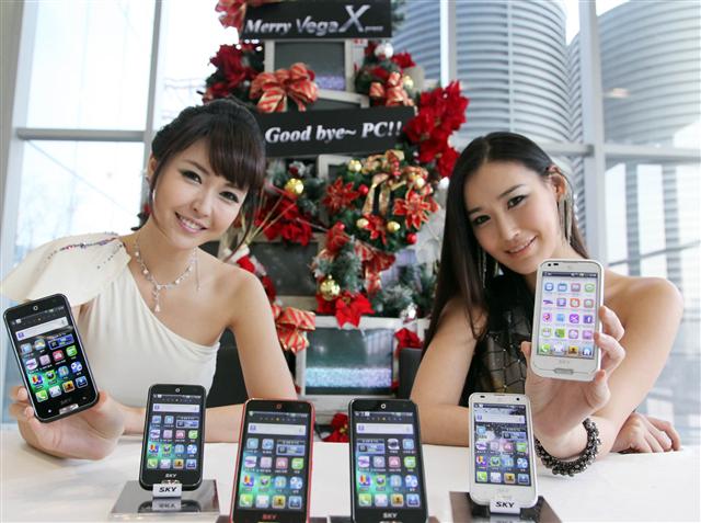 첫 선 보인 ‘베가 엑스’  21일 서울 상암동 팬택 본사에서 모델들이 새로 출시하는 스마트폰 ‘베가 엑스’를 선보이고 있다. 팬택 제공