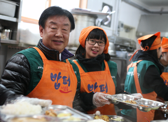 성탄절을 하루 앞둔 지난 24일 동부화재 김정남(왼쪽) 사장이 서울 청량리 사랑의 밥퍼운동본부에서 무료급식 봉사활동을 하고 있다. 동부화재 제공