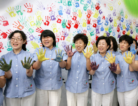 사회적 기업 ‘다솜이 재단’ 창립 행사에 참가한 간병인들이 새 출발을 기념하는 손도장을 찍고 밝게 웃고 있다. 교보생명 제공