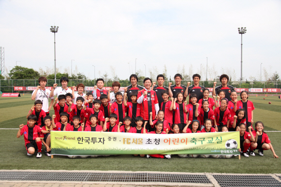 한국투자증권이 지난 6월 개최한 ‘어린이 축구교실’에서 FC서울 축구단 선수들과 복지시설 어린이 40여명이 기념촬영을 하고 있다. 한국투자증권 제공