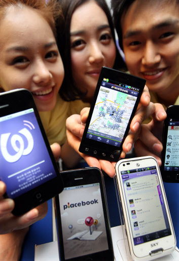 13일 LG유플러스 홍보 도우미들이 스마트폰 애플리케이션으로 출시한 ‘와글’(Wagle)과 ‘플레이스북’(placebook) 등 소셜네트워크 서비스 2종을 소개하고 있다.  LG유플러스 제공