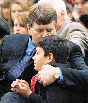 굿바이 크리스티나  13일(현지시간) 미국 애리조나 총기 난사 사건의 희생자인 크리스티나 그린의 장례식에서 아버지 존(왼쪽)이 아들 달라스를 껴안은 채 슬픔에 잠겨 있다.  투손 AP 연합뉴스 