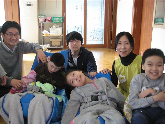 명진(뒷줄 가운데)군과 아버지 전수호(뒷줄 왼쪽)씨, 어머니 석주혜(뒷줄 오른쪽)씨가 지난 29일 서울 체부동 라파엘의 집에서 장애아동들을 돌보고 있다. 