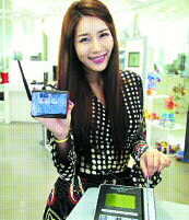 SKT의 홍보 모델이 10일 서울 중구의 한 매장에서 SKT의 데이터 MVNO용 이동통신 모뎀이 연결된 신용카드 단말기에서 결제를 시연하고 있다.  SKT 제공 