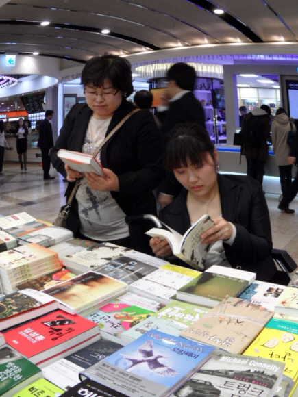 18일 서울 광화문 교보문고를 찾은 김빛나(오른쪽)씨와 활동 보조인 이경선씨가 새로나온 책의 내용을 살펴보고 있다.