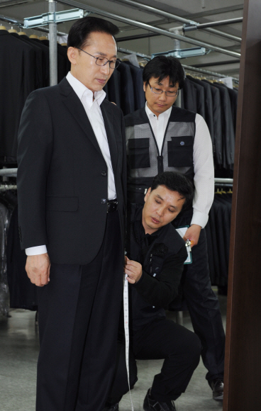 이명박(왼쪽) 대통령이 20일 서울 독산동 ㈜아름다운사람을 방문해 직접 신사복을 맞추고 있다. 청와대 사진기자단 