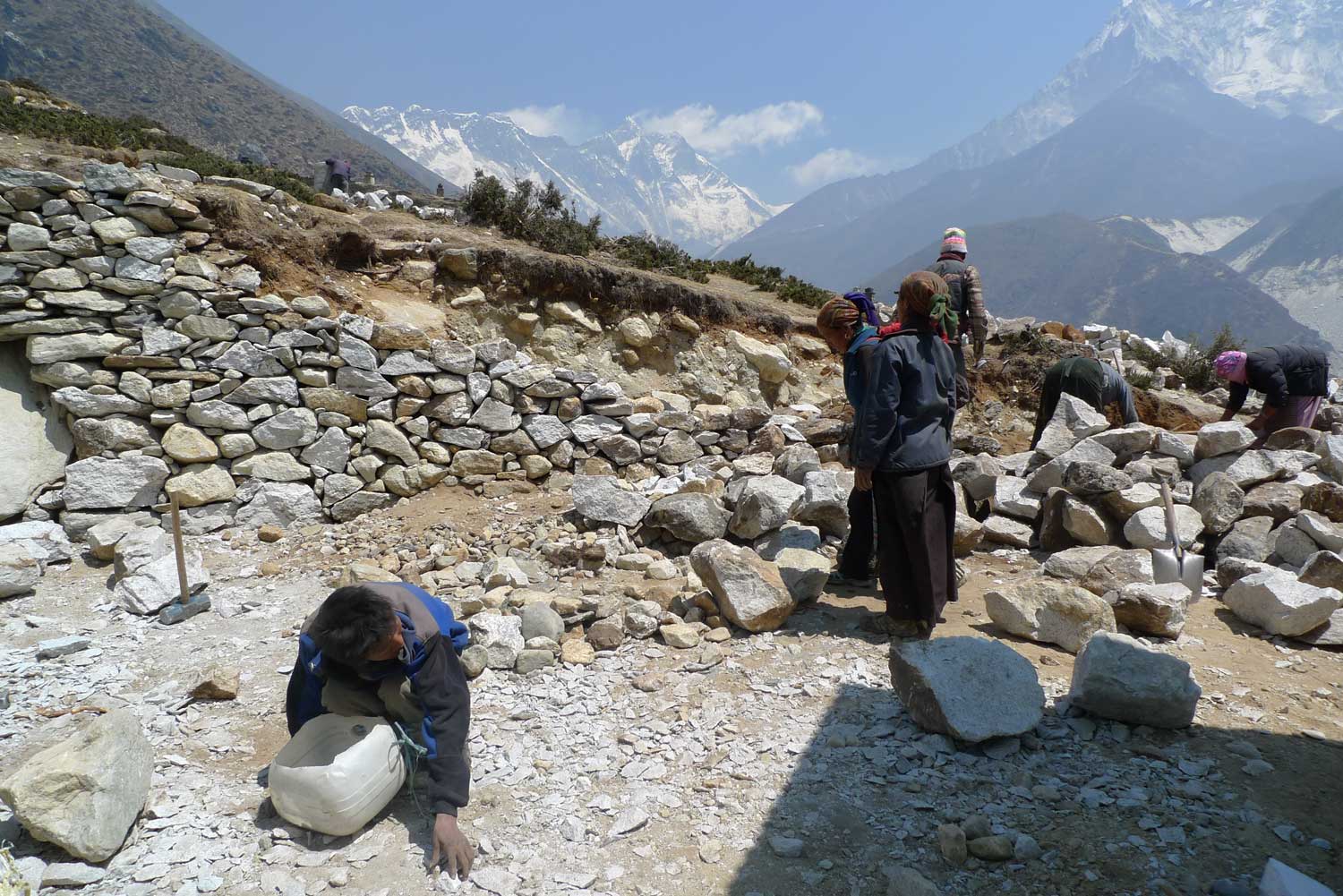 엄홍길휴먼재단이 네팔에 짓는 16곳의 학교 가운데 첫 번째로 완공된 팡보체 휴먼스쿨 공사 현장에서 주민과 아이들이 주춧돌을 옮기고 있다. 오른쪽에 보이는 것이 아마다블람.