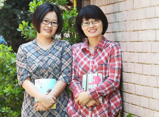 일란성 쌍둥이 자매 작가인 장은진(오른쪽)과 김희진이 갓 펴낸 각자의 장편소설을 들고 환히 웃고 있다. 두 사람은 “언젠가는 시나리오를 함께 써 보고 싶다.”고 입을 모았다.  연합뉴스