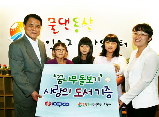 김쌍수(왼쪽) 한국전력공사 사장이 서울 일원동 물댄동산 일원지역아동센터에 ‘사랑의 도서’를 전달하고 센터 지도 교사 및 아이들과 기념 촬영하고 있다.  한국전력 제공