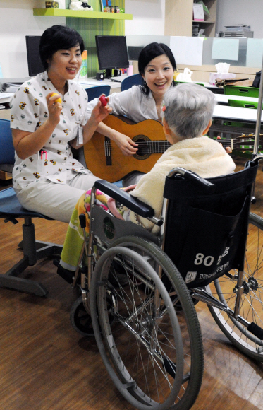 ③ 환자와 함께 기타를 치며 노래를 부르는 간호사와 음악치료사(고대구로병원).