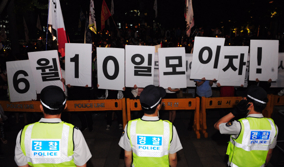 “반값 등록금 실현하자”  대학생과 시민단체 회원 등 900여명(경찰 추산)이 7일 오후 서울 태평로 파이낸스센터 앞에서 반값 등록금 실현을 위한 촛불집회를 개최한 가운데 참가자들이 ‘6월 10일 모이자’는 문구를 들고 서 있다.  손형준기자 boltagoo@seoul.co.kr