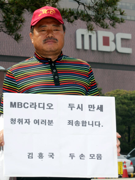 가수 김흥국씨가 13일 오전 서울 여의도 MBC 사옥 앞에서 라디오 프로그램 MC 퇴출에 항의하는 1인 피켓시위를 하고 있다. 연합뉴스