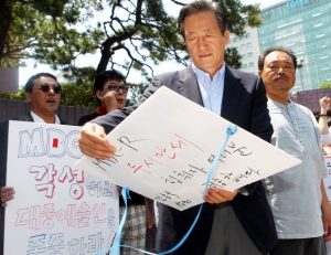 한나라당 정몽준 의원이 17일 오후 서울 영등포구 여의도동 MBC 사옥 앞에서 MBC 라디오 표준 FM < 2시 만세 >에서 하차한 것에 항의해 1인 시위를 이어가고 있던 가수 김흥국을 방문해 피켓 문구를 읽고 있다.<br>연합뉴스