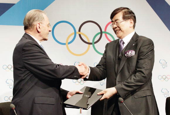 조양호(오른쪽) 2018년 평창동계올림픽 유치위원장이 6일(현지시간) 남아공 더반의 국제컨벤션센터에서 열린 개최도시 조인식에서 자크 로게 국제올림픽위원회(IOC) 위원장과 약정서에 서명한 뒤 악수하고 있다. 더반 연합뉴스