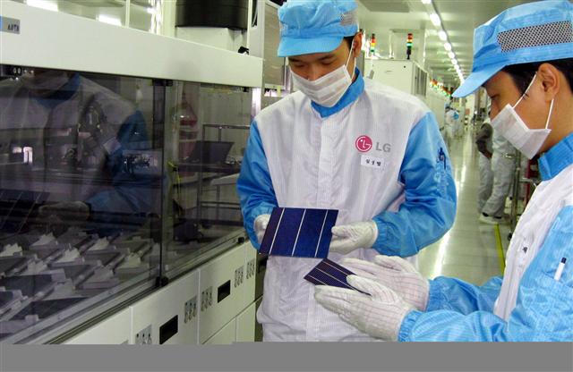 LG전자 구미공장 연구원들이 직접 생산한 태양전지 패널을 살펴보며 점검하고 있다. LG전자 제공