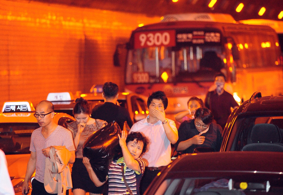 남산1호터널 퇴근길 불… 연기에 숨막힌 시민들 긴급대피 14일 오후 6시쯤 서울 남산1호터널에서 한남대교 방향으로 달리던 택시에서 불이 나자 승용차와 버스에서 내린 시민들이 연기 때문에 입을 막은 채 터널 밖으로 빠져나오고 있다. 불은 택시 엔진이 과열돼 발생한 것으로 추정된다. 소방대원들이 긴급 투입돼 불은 20분 만에 꺼졌고, 차량 운전자들과 버스 승객들은 사고 뒤 곧바로 대피해 인명피해는 없었다. 하지만 터널이 1시간 20분 동안 통제돼 일대에 극심한 교통혼란이 빚어졌다.  정연호기자 tpgod@seoul.co.kr