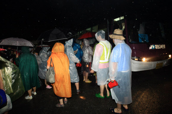 강원 고성군 세계잼버리수련장에서 진행 중인 국제야영에 참가한 걸스카우트 대원들이 한밤중 쏟아진 폭우에 긴급대피하고 있다.  연합뉴스
