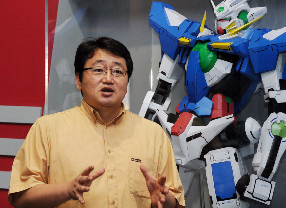 지난 25일 오후 경기 과천 서울대공원 입구에 국내 최초로 세운 ‘취미박물관’에서 엄윤성 대표가 ‘건담’(Gundam) 로봇을 배경으로 포즈를 취했다.