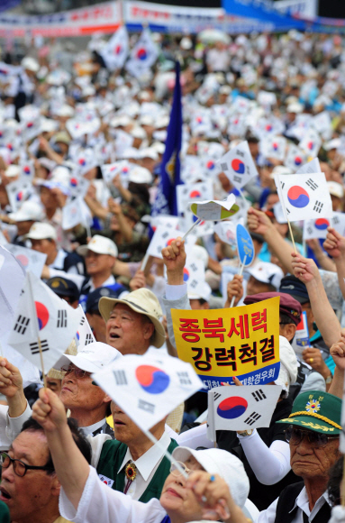 올해 광복절도 보수 및 진보단체들이 따로따로 기념행사를 가졌다. 15일 오후 서울광장에서 보수단체 주최로 열린 행사에 참여한 시민들이 ‘종북세력 척결’, ‘교육 바로 세우기’ 등을 요구하는 피켓과 함께 태극기를 흔들고 있다.  손형준기자 boltagoo@seoul.co.kr