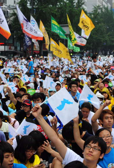 같은 날 오전 서울광장 앞 도로에서 열린 진보단체의 ‘한반도 자주평화통일을 위한 범국민대회’에서 참가자들이 한반도기를 흔들고 있다. 손형준기자 boltagoo@seoul.co.kr 