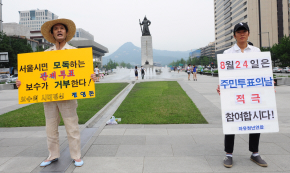 1인 시위도 신경전  22일 서울 광화문광장에서 무상급식 주민투표 참여를 독려하며 1인 시위를 벌이는 보수단체 회원 옆에서 보수를 자처하는 한 시민이 투표 거부 피켓을 들고 1인 시위를 벌이고 있다. 손형준기자 boltagoo@seoul.co.kr 