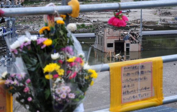 일본 미야기현 이시노마키시 오나가와 정립병원 주차장에 희생자들을 애도하기 위해 놓여진 조화 뒤로 부서진 건물이 보인다. 이시노마키·나토리·이이다테무라 손형준기자 boltagoo@seoul.co.kr 