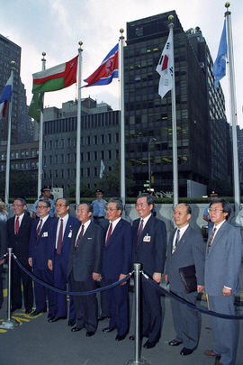이상옥(왼쪽 네 번째) 당시 외무장관과 노창희(다섯 번째) 대사 등 한국 대표단이 1991년 9월 17일 남북한 유엔 동시 가입 뒤 양국 국기가 나란히 게양돼 있는 미국 뉴욕의 유엔본부 앞에서 밝게 웃고 있다. 유엔 홈페이지