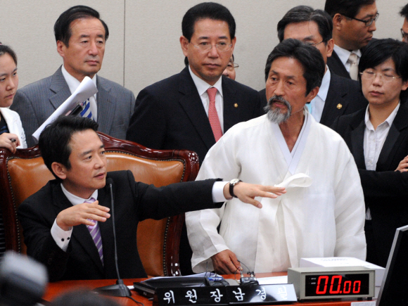 16일 오후 국회 외교통상통일위원회에서 남경필(왼쪽) 위원장이 한·미 자유무역협정(FTA) 비준안을 전격 상정하자 민주노동당 강기갑(오른쪽 두 번째) 의원 등 야당 의원들이 의장석을 에워싼 채 항의하고 있다. 이언탁기자 utl@seoul.co.kr