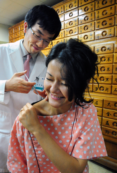어깨 통증을 치료하기 위해 한국을 방문한 우크라이나 여성이 약침 치료를 받고 있다(자생한방병원).