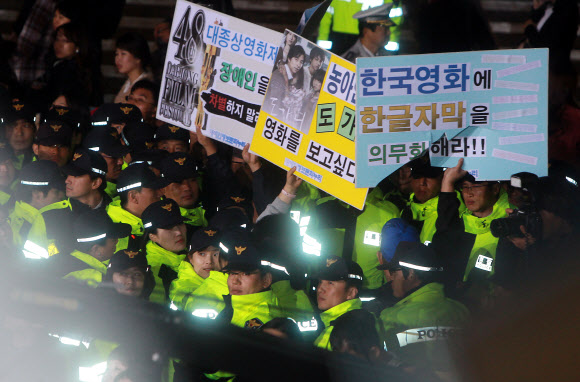 장애인들 “도가니 보고 싶다”   17일 오후 제48회 대종상영화제 시상식이 진행되던 서울 세종문화회관 앞에서 장애인단체 회원들이 ‘한국 영화에 한글 자막을 넣어 달라’, ‘영화 도가니를 보고 싶다’라는 등의 피켓 시위를 하고 있다.   연합뉴스 