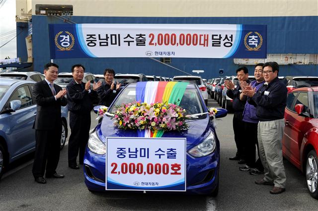 지난 22일 울산 선적부두에서 현대차 관계자들이 중남미 지역으로 수출되는 200만번째 차량인 엑센트를 배경으로 기념촬영을 하고 있다.  현대차 제공