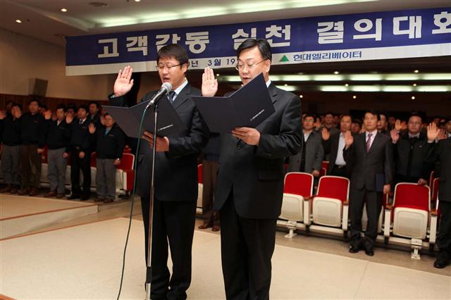 문완기(오른쪽) 현대엘리베이터 서비스사업본부장이 협력업체 대표와 고객감동 실천을 다짐하고 있다.  현대그룹 제공