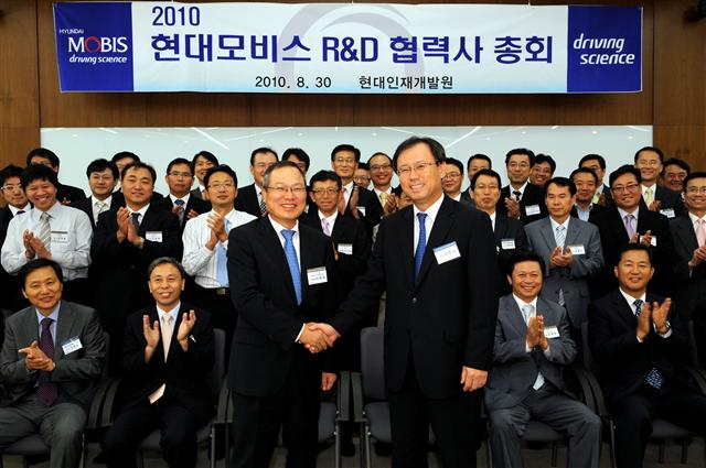 경기도 용인 현대인재개발원에서 열린 ‘R&D 포럼’에 참가한 전호석(앞줄 오른쪽) 현대모비스 사장과 박종호 유라코퍼레이션 전무가 상생협력을 다짐하며 악수하고 있다. 현대모비스 제공