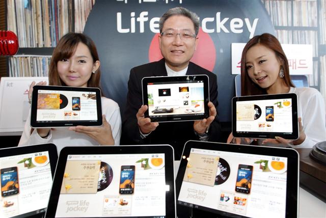 가정용 태블릿 PC ‘스마트홈 패드’ 출시를 앞두고 27일 서울 광화문 올레스퀘어에서 열린 ‘스마트홈 패드 론칭쇼’에서 서유열(가운데) KT 홈고객부문 사장과 모델들이 스마트홈 패드를 소개하고 있다.  KT 제공