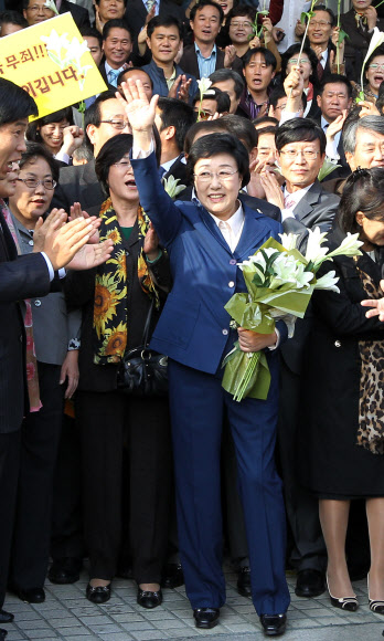 한신건영 전 대표 한만호 씨로부터 대선 경선 자금 명목으로 현금과 달러 등 9억여 원을 받은 혐의(정치자금법위반)로 기소된 한명숙 전 총리가 31일 서울중앙지방법원에서 열린 1심 선고공판에서 무죄판결을 받은 뒤 손을 들어  인사하고 있다. 연합뉴스