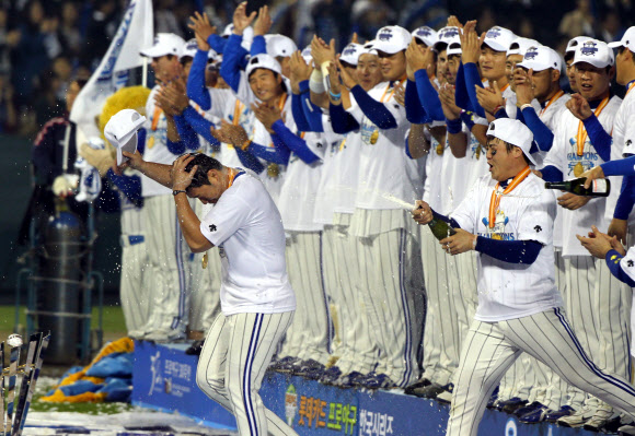 31일 한국시리즈 우승 시상식에서 프로야구 삼성 안지만(앞줄 오른쪽)이 시리즈 MVP 오승환(왼쪽)에게 샴페인을 터뜨리며 축하해 주고 있다. 연합뉴스